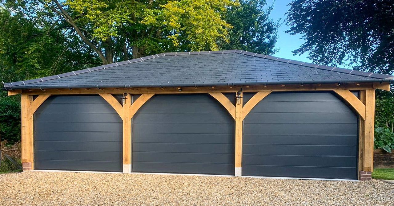 Three anthracite sectional garage doors fitted under an oak frame
